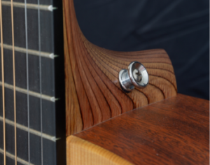 A strap button on the heel of an acoustic guitar