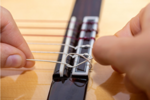 Classical guitar being restrung