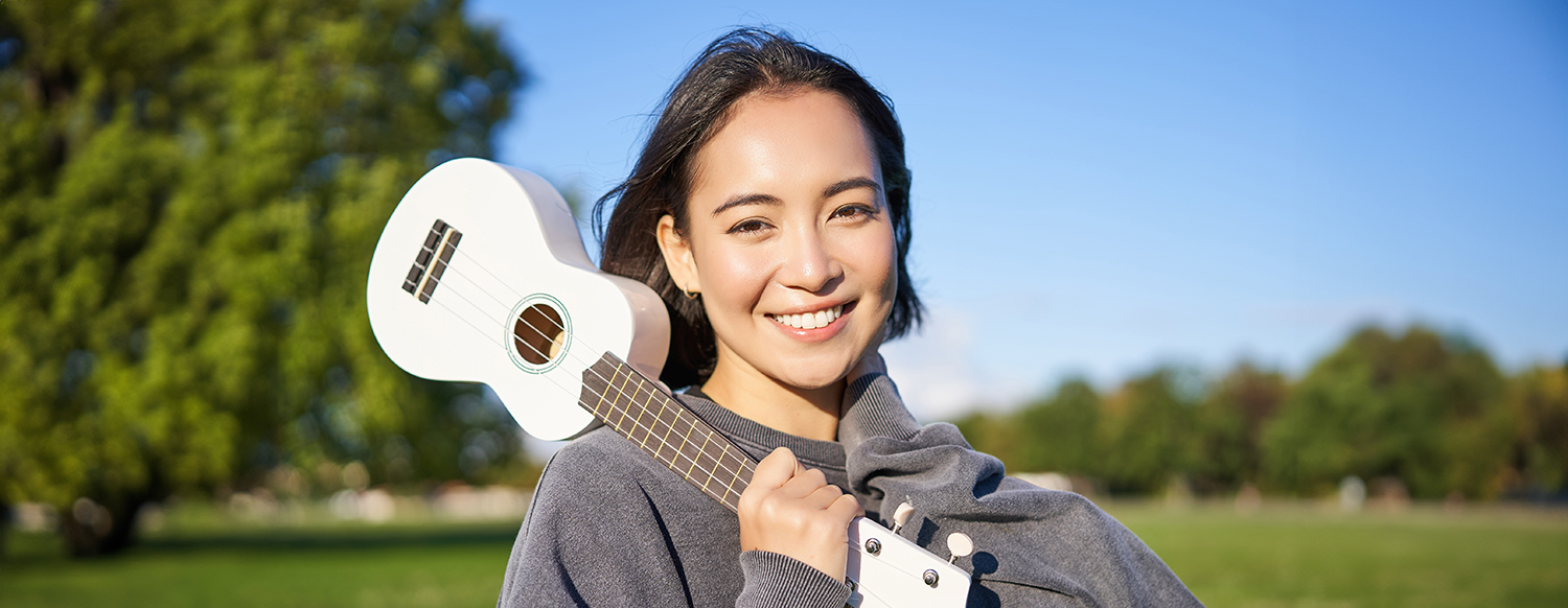 Asian Woman with Ukulele Outdoors