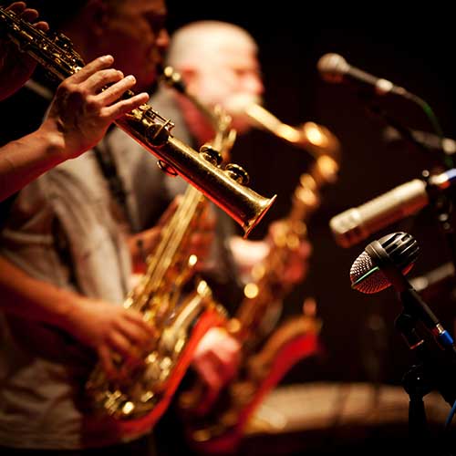 A close up of a clarinet with the rest of a horn section in the background